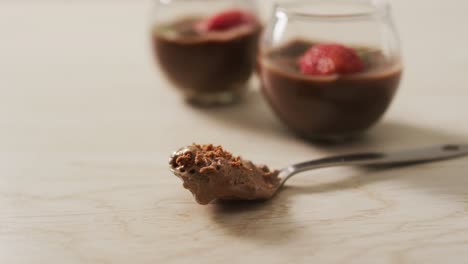 video of chocolate pudding with strawberries and bluberries on a wooden surface