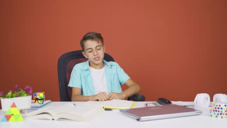 niño cerrando la computadora portátil con expresión de enojo.