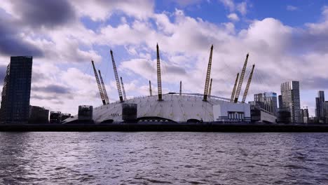 Landscape-view-of-the-Millennium-Dome-from-a-Moving-Boat-on-the-River-Thames,-Cloudy-Day