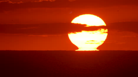 Nahaufnahme-Eines-Sonnenaufgangs,-Während-Die-Sonne-Vom-Ozeanhorizont-Wegreißt-Und-Den-Himmel-Orange-Und-Rosa-Glüht