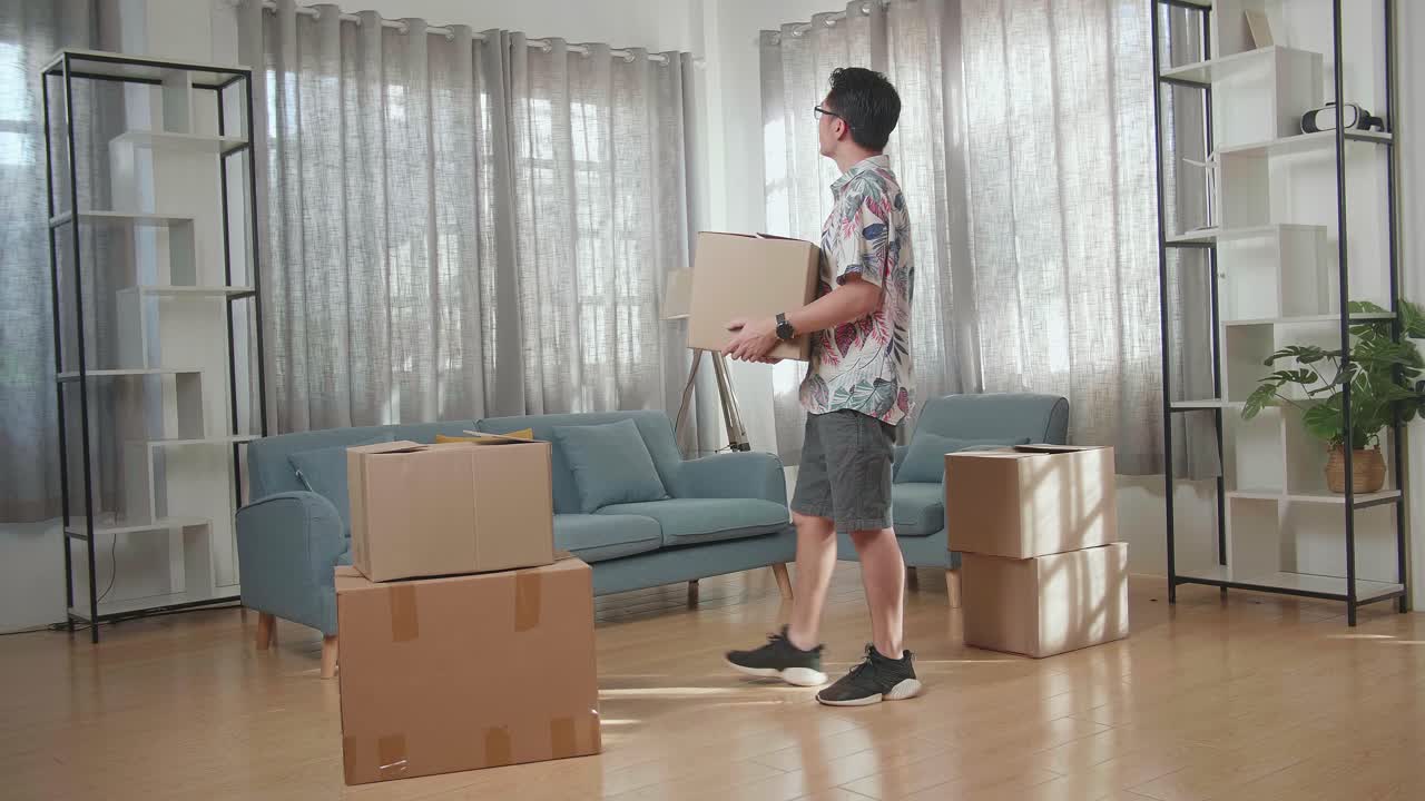 사람 은 거실 에서 상자 를 옮기고 있다