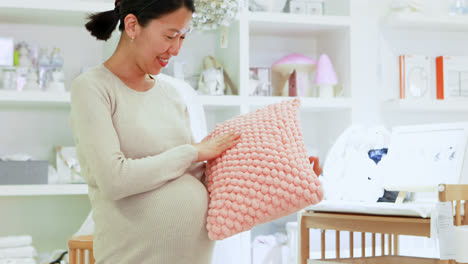 pregnant woman holding pillow in bedroom 4k