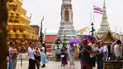 visitors explore the temple with vibrant umbrellas