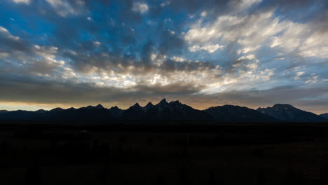 grand teton mountain range at dawn and dusk with dramatic skies