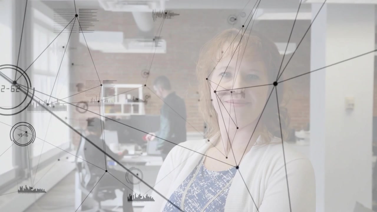 Diverse coworkers working while woman standing in open office and data overlay moving over screens