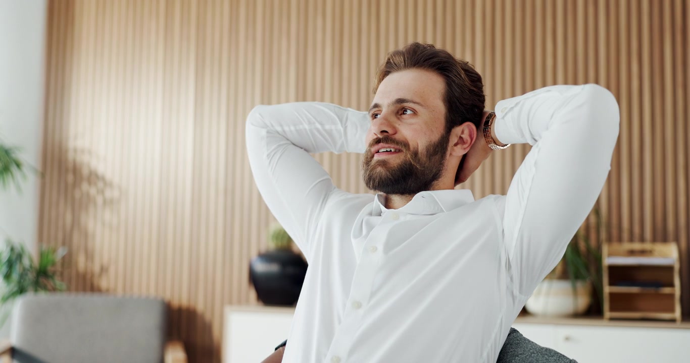 Hombre de negocios cerrando su portátil y relajándose en una oficina moderna