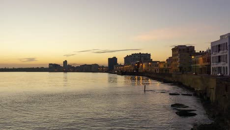 Beautiful-Time-Lapse-view-of-the-Old-Havana-City,-Capital-of-Cuba,-by-the-Ocean-Coast-during-a-vibrant-sunny-and-colorful-sunrise