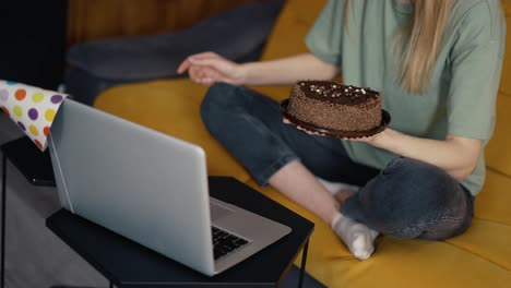 mujer irreconocible celebrando un cumpleaños lejano en línea con amigos video chat