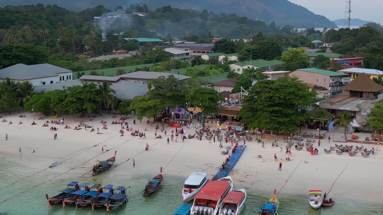 태국 해변에서 해가 지고, 관광객들이 풍경을 즐기고 있습니다.
