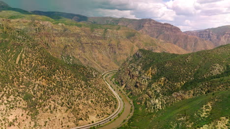 gorgeous view of beautiful mountains of colorado state, usa. wavy river separating the mountains and roads going along the waterfront from top view.
