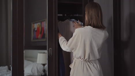 woman getting dressed in a bedroom closet