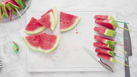 slicing red watermelon into small pieces