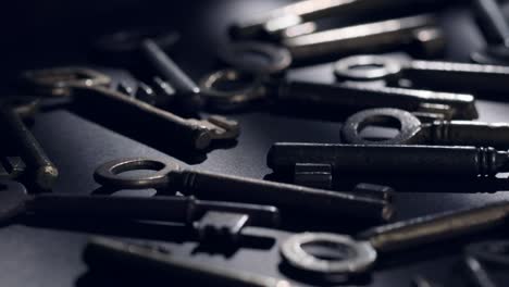 Old keys rotating over black background