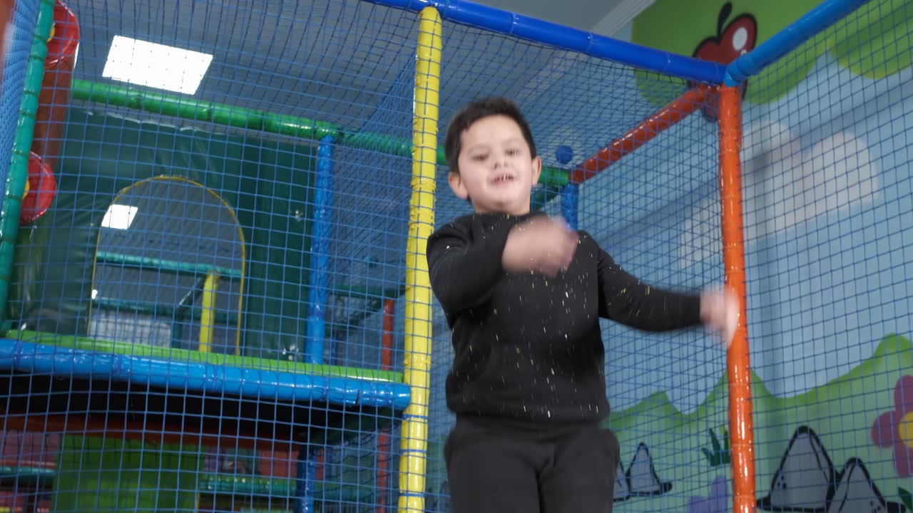 5-year-old boy jumping happy on the trampoline at the play center