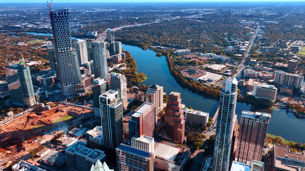 Austin, USA, 21. marraskuuta 2025: Lähestytään kauniita korkeita rakennuksia Colorado-joen rannalla. Valtava rakennustyömaa on Austinin, Texasin, USA:n keskusta-aluetta. Kaupunkikuvassa on paljon vihreyttä. Ilmakuva