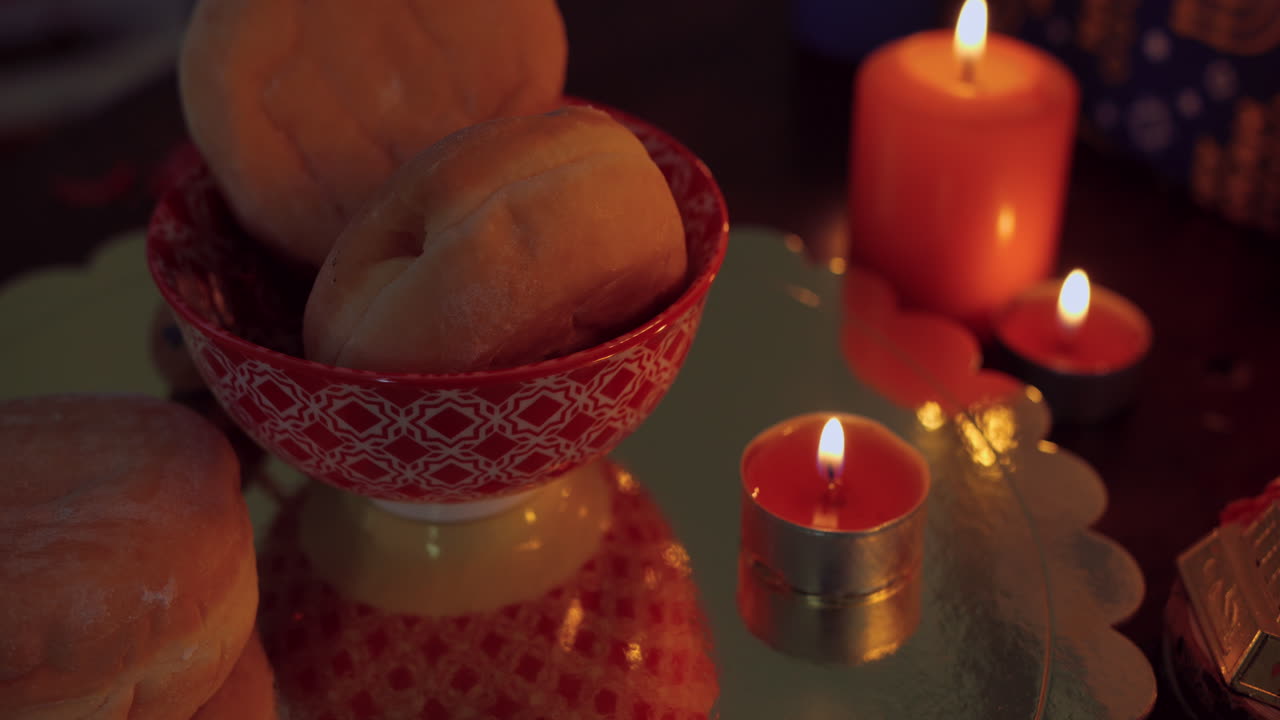 Warm Glow of Lit Candles and Bread Rolls on a Table