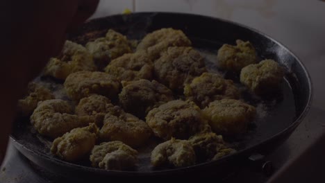 indian women hand fring rawa prawns in black hot pan