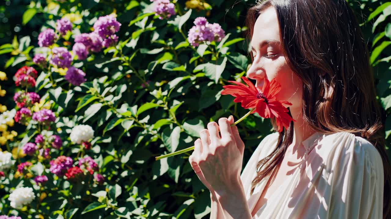 Una serena scena video di una donna in un giardino, ripresa da un'angolazione laterale, che evidenzia la vivacità