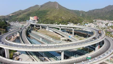 Verkehr-Auf-Einem-Massiven-Autobahnkreuz-Mit-Mehreren-Ebenen-Und-Schleifenförmiger-Straße-In-Hongkong,-Luftbild