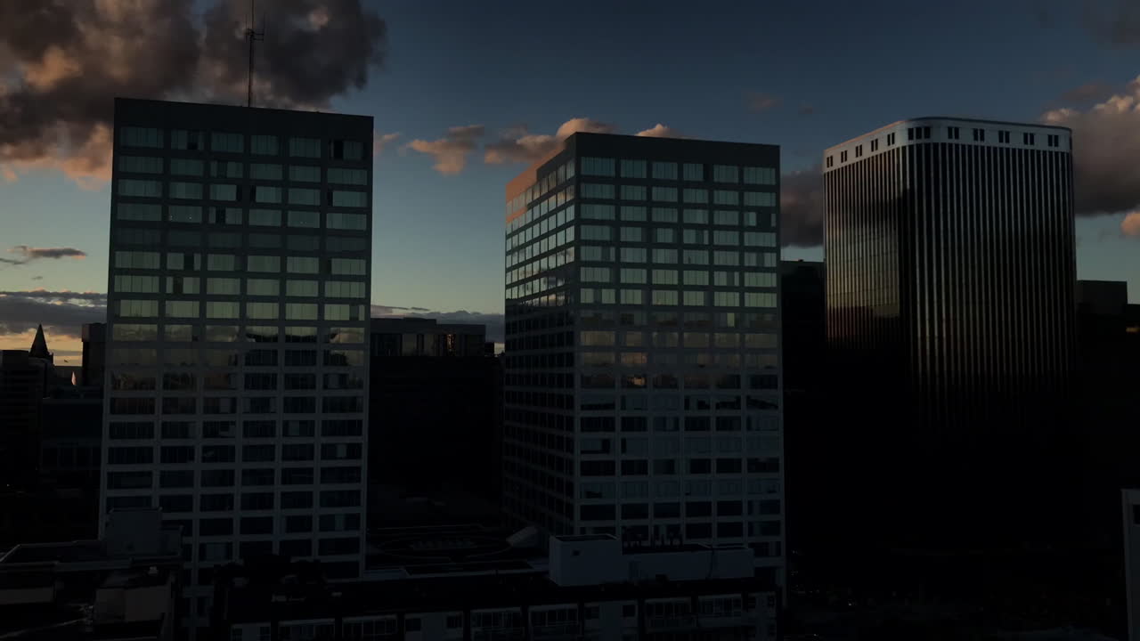 time-lapse del atardecer de los edificios de la ciudad en el centro de ottawa, con nubes y reflejos que se mueven rápidamente