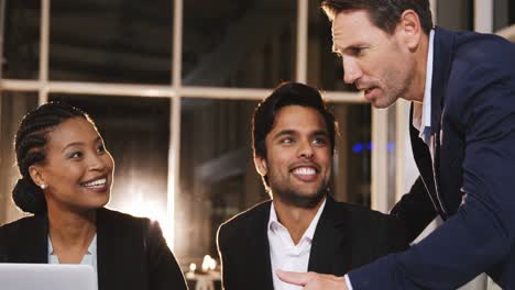 Businessman-discussing-with-colleagues-over-laptop