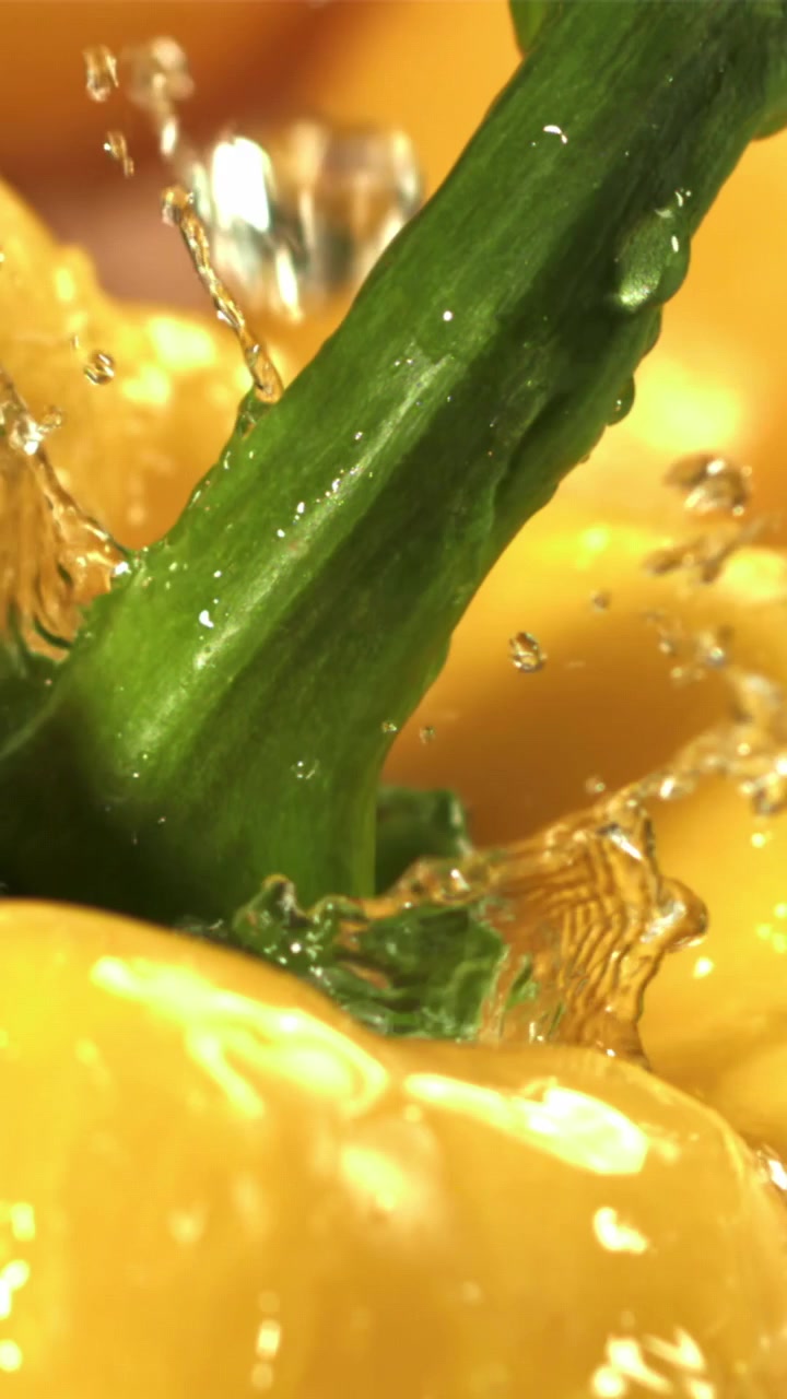Acqua che schizza al rallentatore su un peperone giallo vivace