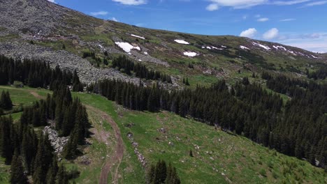 Drone-shot-of-a-mountain-hill-in-spring-with-some-snow-still-lingering