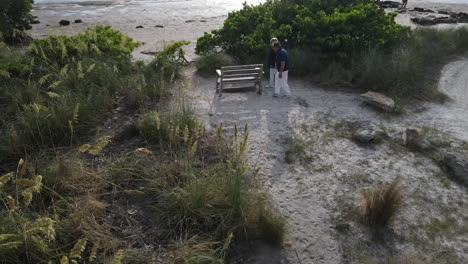 Liebevolle-Lateinamerikanische-Senioren-Halten-Sich-An-Den-Händen,-Während-Sie-Bei-Einem-Romantischen-Spaziergang-Zum-Strand-Gehen