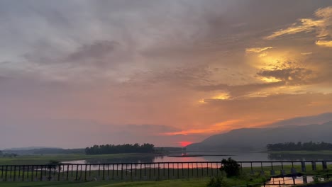 Vista-Panorámica-De-La-Puesta-De-Sol-Sobre-El-Lago-Tranquilo-Y-Los-Campos-Rurales-En-Lonavala,-Cerca-De-Mumbai,-India