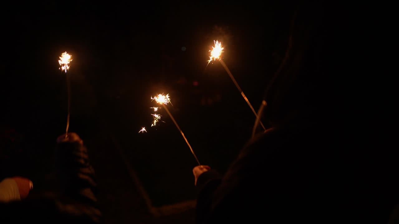 gente encendiendo bengalas en la oscuridad y agitándolas para divertirse y emocionarse