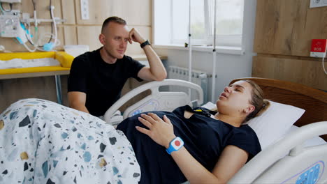 supportive husband by pregnant wife's hospital bed