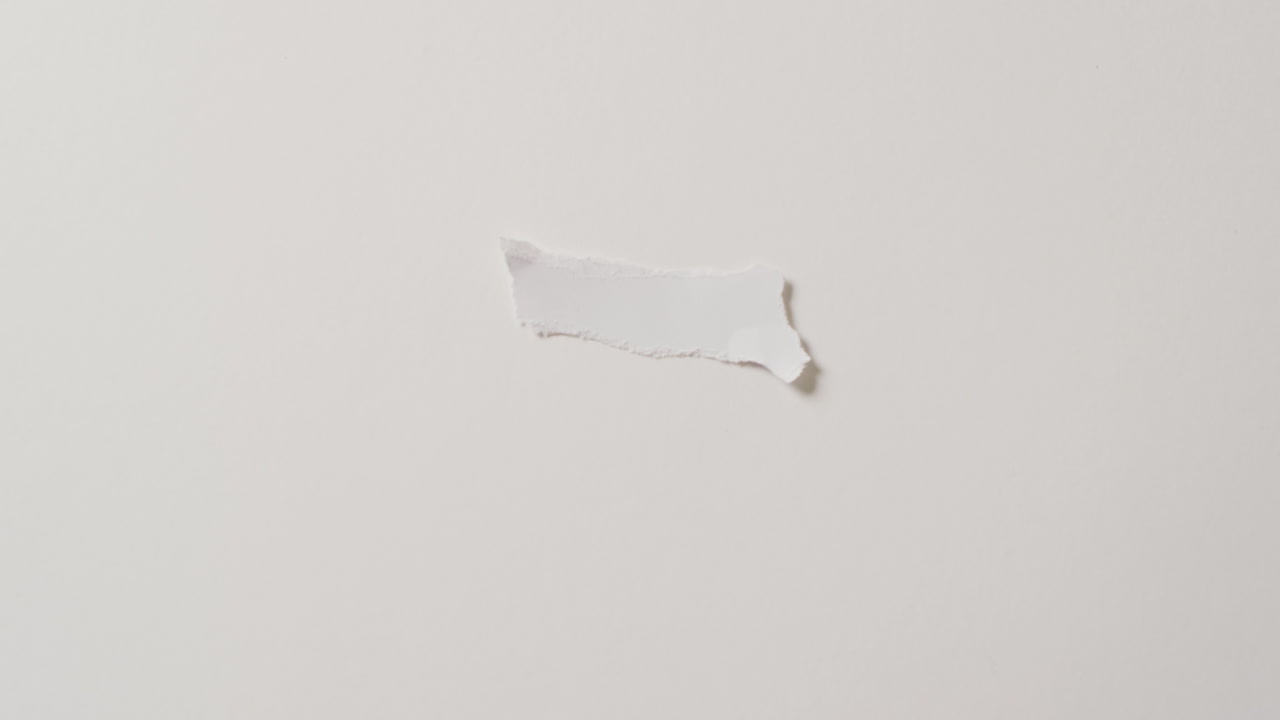 Video of close up of torn piece of paper with copy space on white background