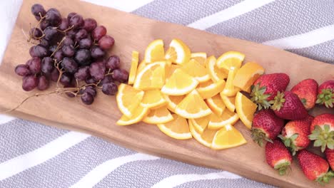 top view of sliced fruit on wooden platter on a blanket outside 1080p 60fps