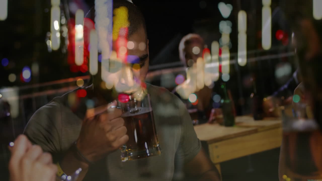 friends sipping drinks around wooden picnic table at night, showcasing animated neon tech icons