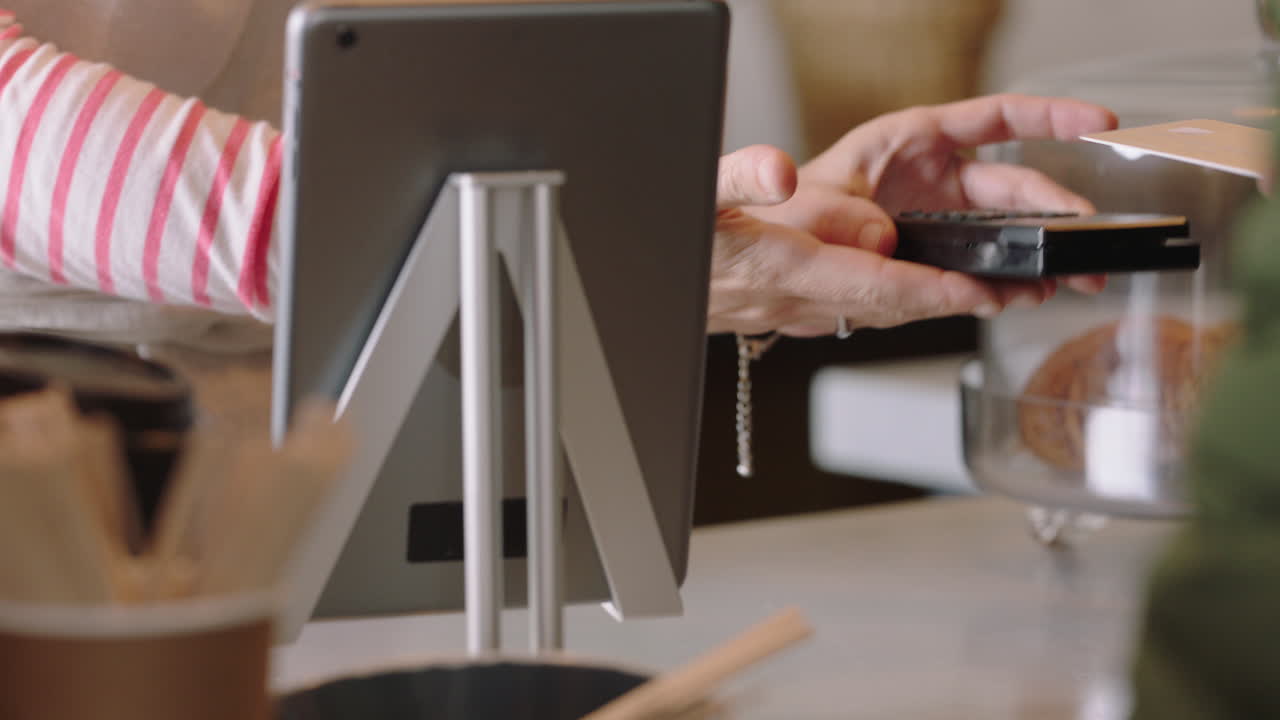 클로즈업  ⁇ 드 캐시어 여성 고객 서비스 신용카드 사용 결제 무선 거래에 돈을 지출 커피 구매 소규모 비즈니스 카페 지원