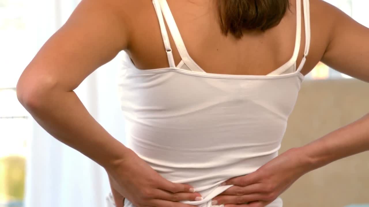 mujer con dolor de espalda en la cama