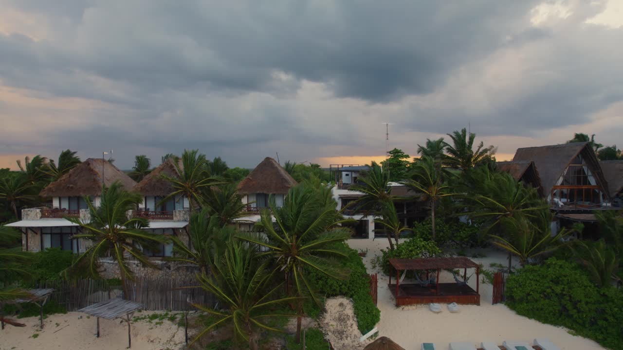 disparo de drones saliendo de un centro turístico en méxico para revelar la playa y el océano durante una tormenta de viento