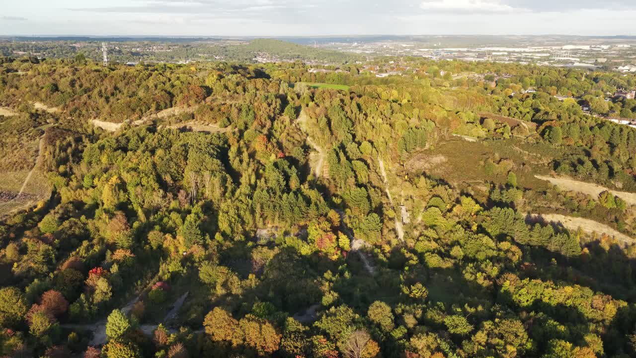 Drone glides over the ruins of Sheffield Ski Village, revealing autumn-colored forest trails and distant city buildings—capturing the contrast between nature, decay, and urban proximity