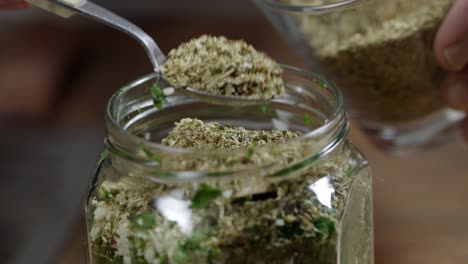 close up, add oregano to a jar with chimichurri sauce mixture