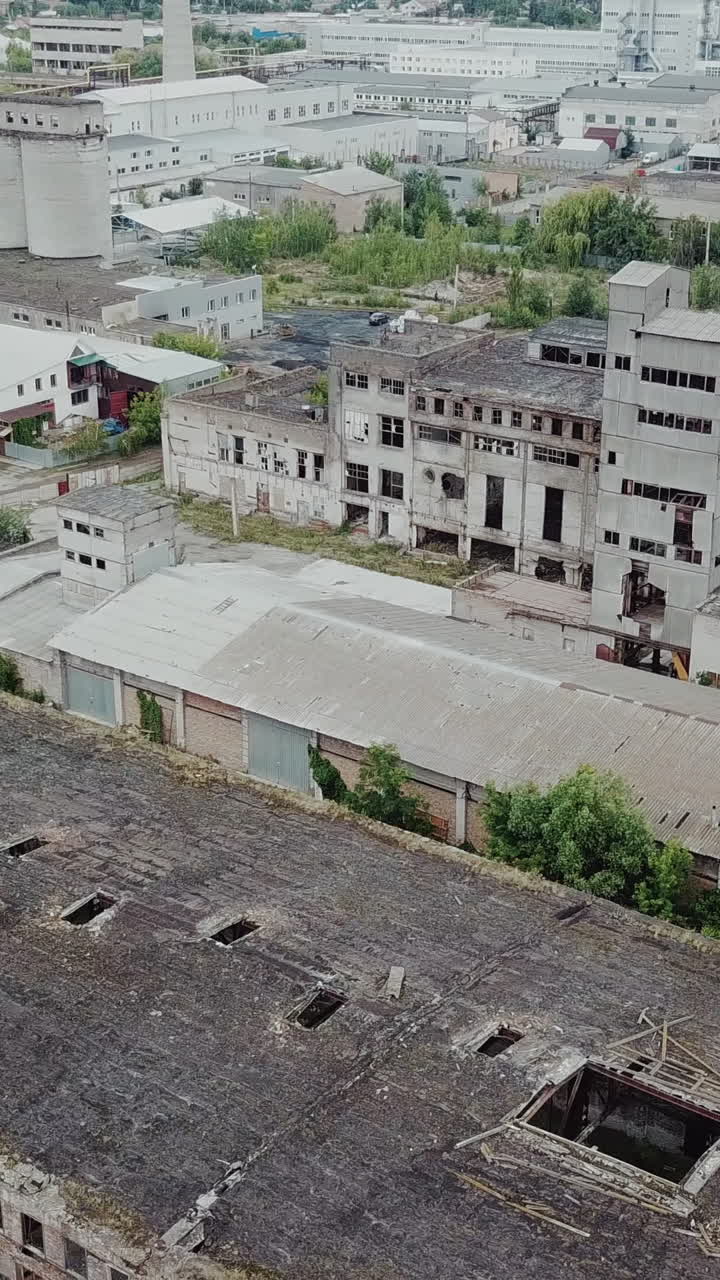 Flight over the destroyed factory. Old industrial building for demolition. Aerial view Vertical video