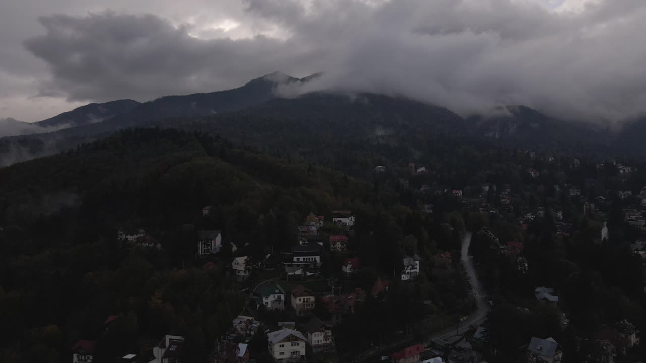 imágenes aéreas de una ciudad de la zona montañosa con el pico de la montaña cubierto de niebla