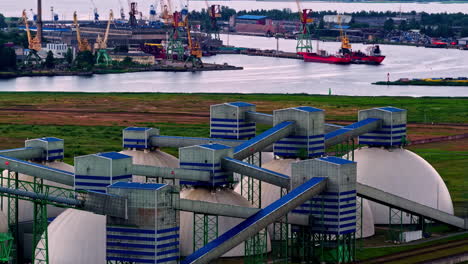 modern industrial domes and conveyor systems at the freeport of riga with docked cargo ships. riga, latvia