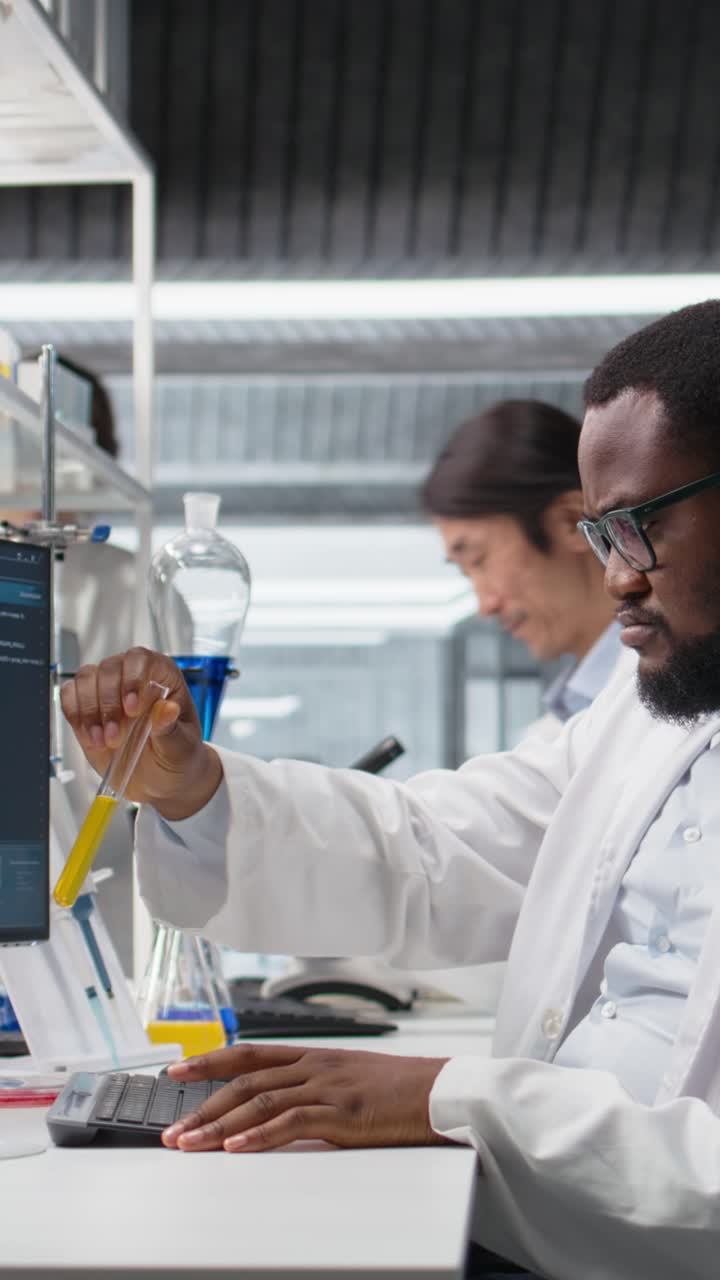 Vertical video Lab scientist evaluates genetic markers using PC, analyzing sample properties