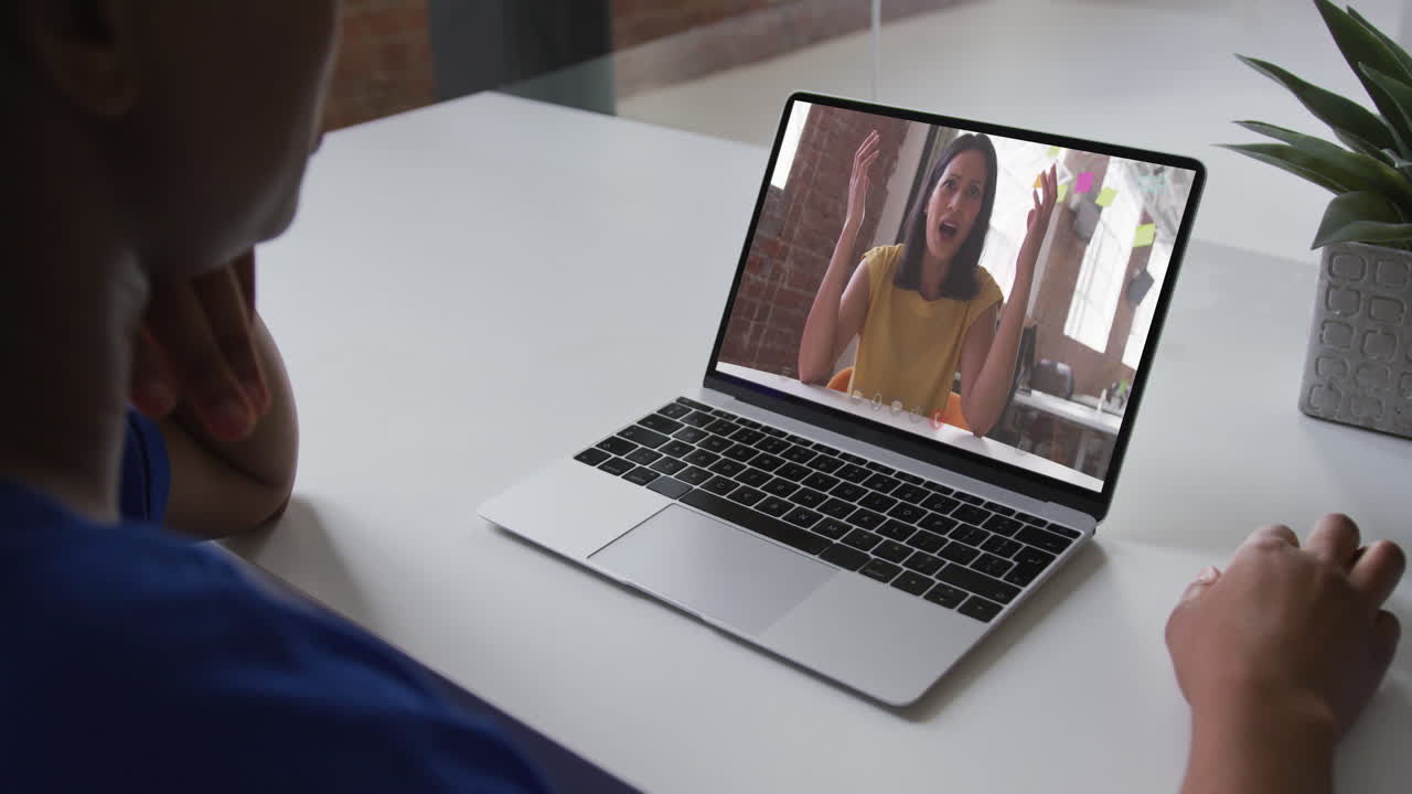 African american woman talking on video call on laptop with female office colleague at home