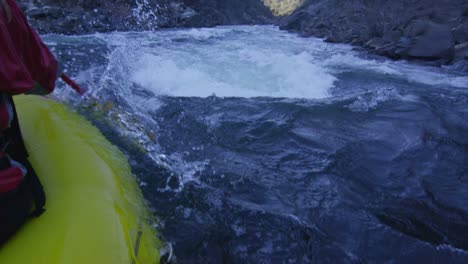 Over-the-shoulder-view-of-a-rafter-paddling-down-a-dangerous-canyon