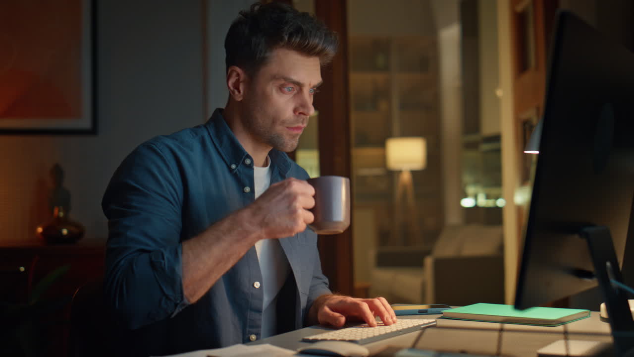 Serious freelancer working home late alone closeup. Manager drinking coffee