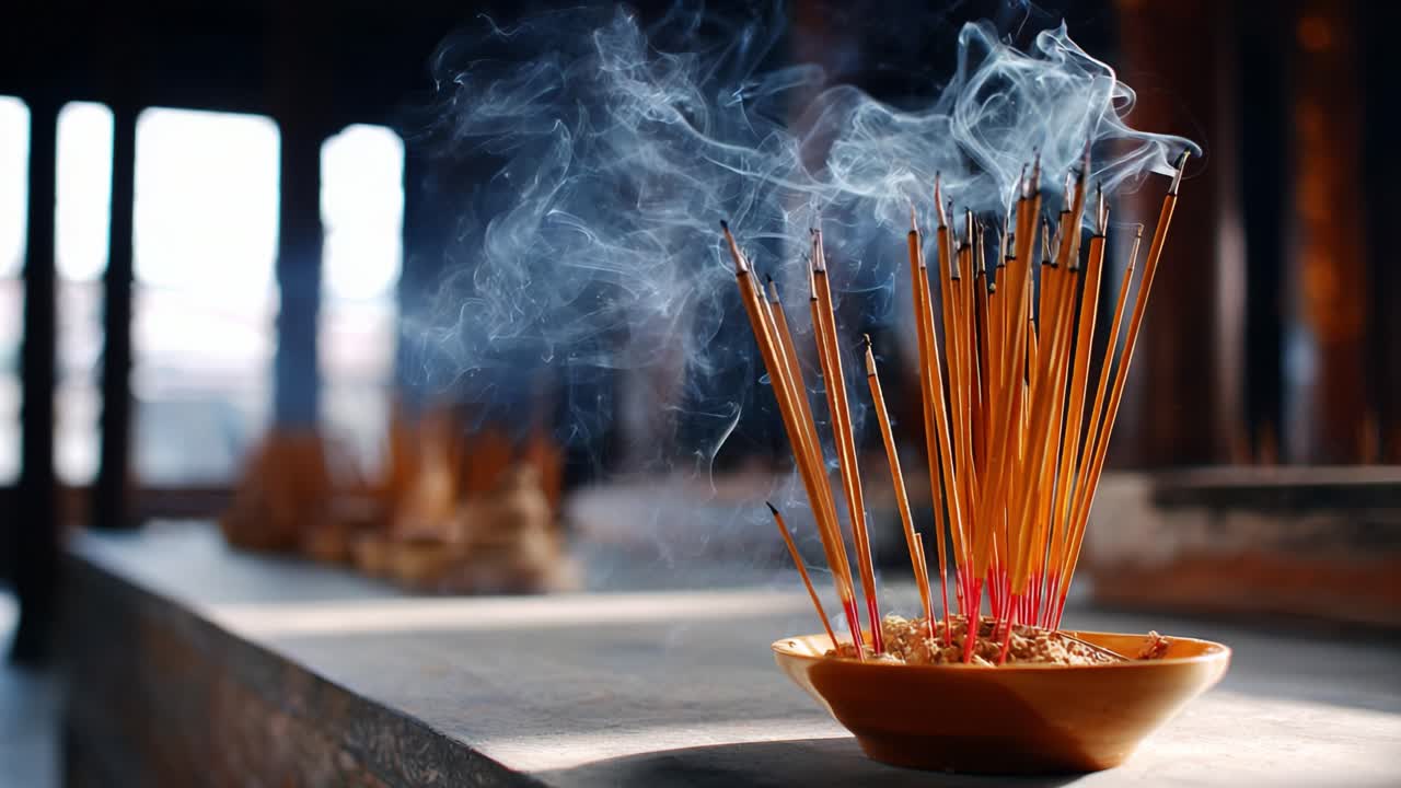 En rolig fremvisning av røkelsespinner som sender ut røykskyer, plassert mot en fredelig bakgrunn, som fanger essensen av meditasjon og spiritualitet i atmosfæren.