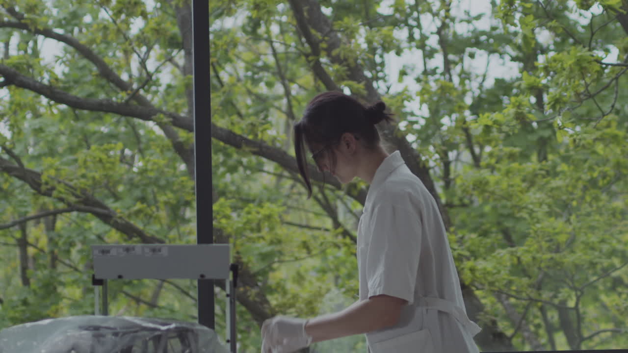 Female scientist checking blood sample in green laboratory with big windows