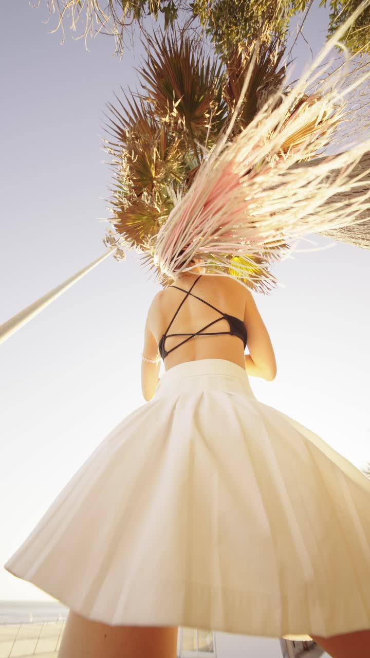 Woman in white skirt under palm tree