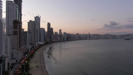 Pedestal-Descendente-Vista-Aérea-De-La-Playa-Balneario-Camboriu,-Crepúsculo